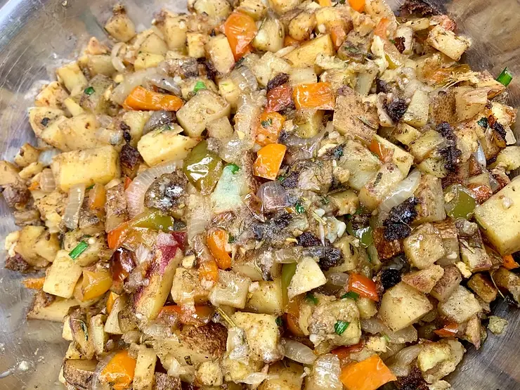 Home fries a la The Garden of Eden cooked over fire with onions, bell peppers, herbs, and spices